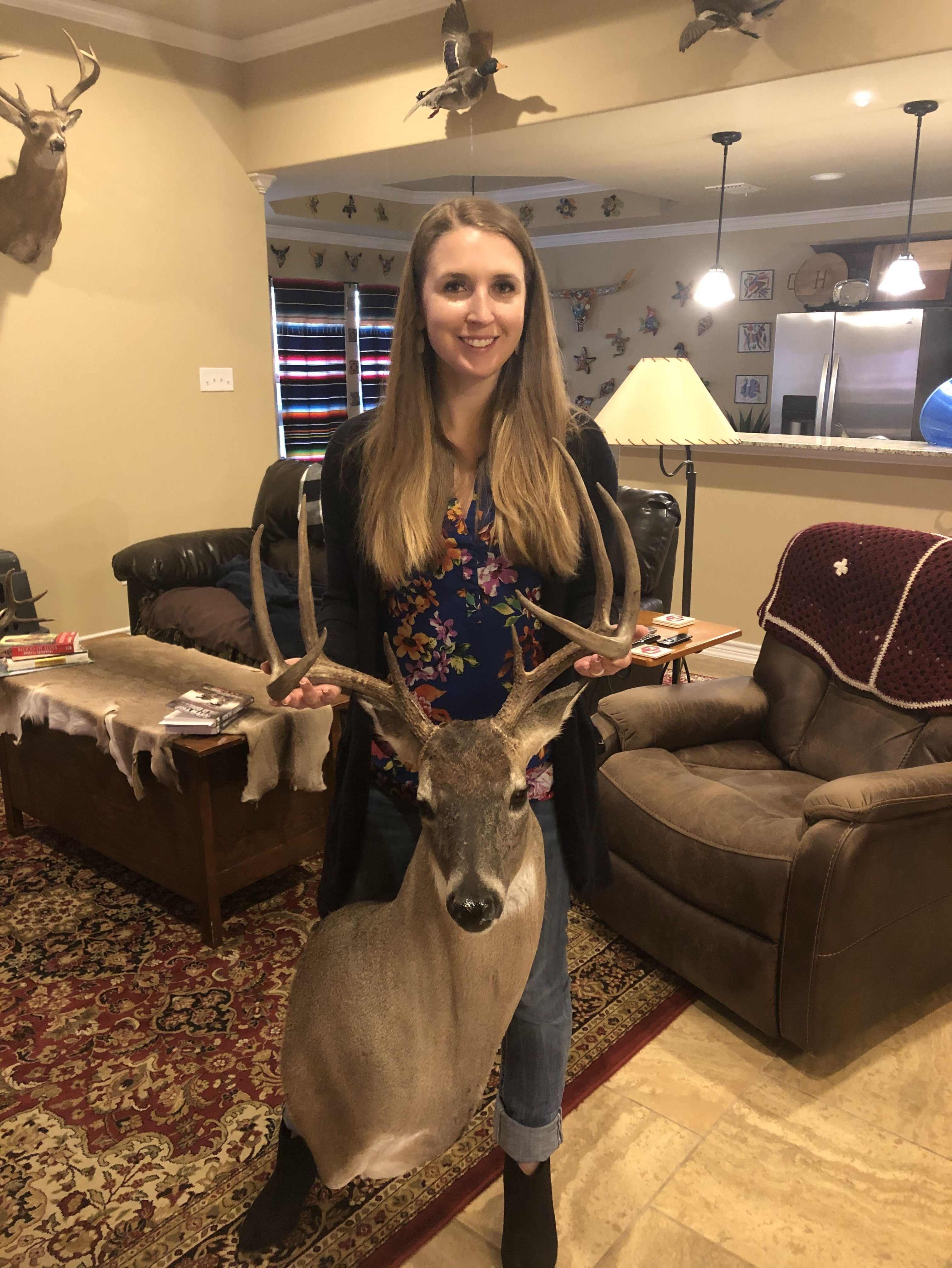 Jessica holding up shoulder mounted white tail deer